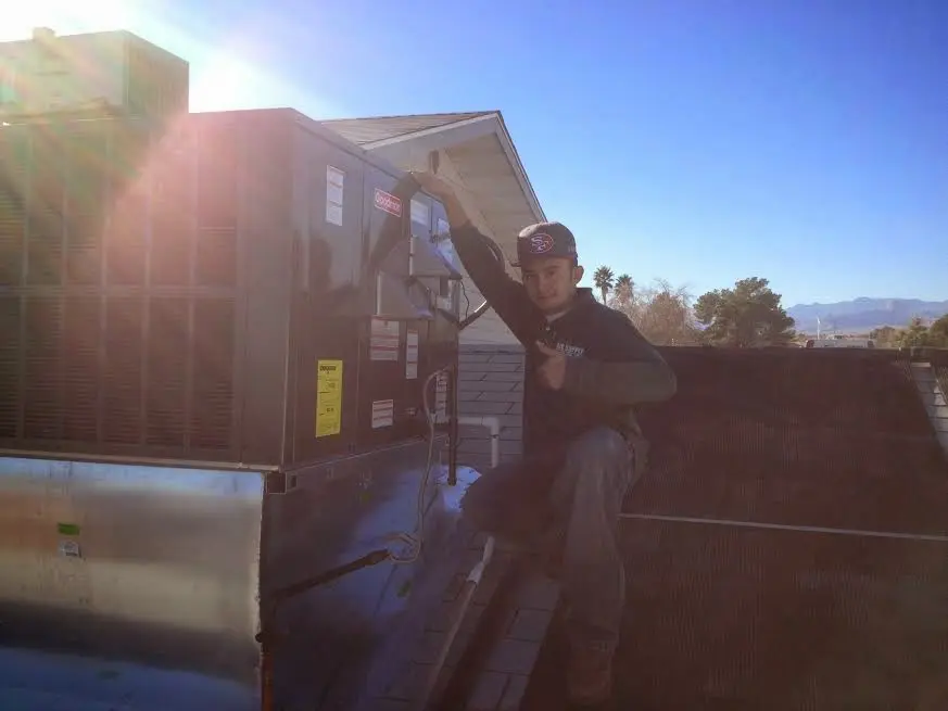 HVAC technician performing HVAC Inspection on a rooftop unit in Webster